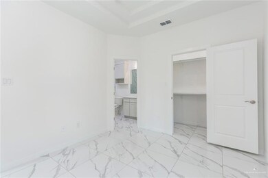 Unfurnished bedroom with visible vents, baseboards, marble finish floor, a raised ceiling, and a walk in closet