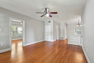 Unfurnished living room featuring ornamental molding, light wood-type flooring, healthy amount of natural light, and a ceiling fan