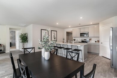Dining area with light wood-style flooring and recessed lighting