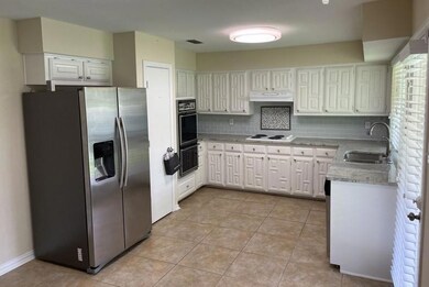 Kitchen with white cabinetry, backsplash, sink, an