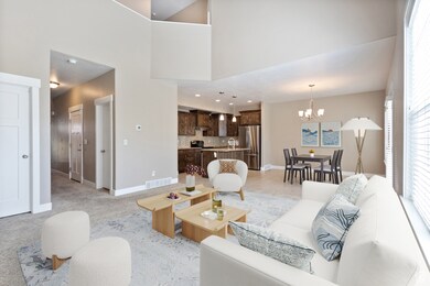 Living room featuring a towering ceiling, light carpet, and a chandelier