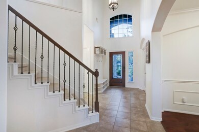 Continuing towards the living areas from the front door you can see the location of the staircase, the high ceilings and large window, the soft arched entryways and accents to the office and dining room.  The foyer transitions seamlessly into the dining area and living areas.
