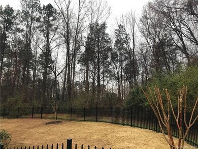 Lot is behind the black fence and continues farthe