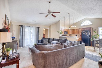 Carpeted living room with high vaulted ceiling, a 