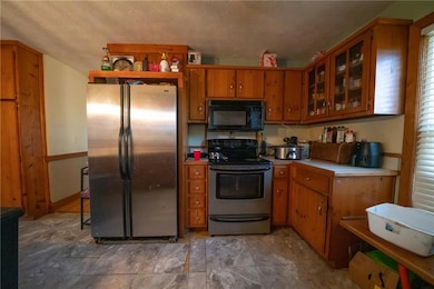 Kitchen featuring a textured ceiling and appliances with stainless steel finishes