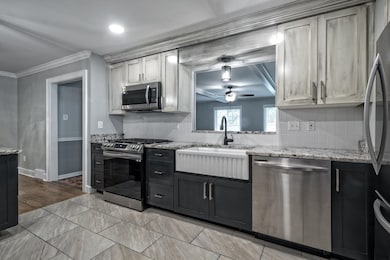 Kitchen with crown molding, a ceiling fan, tastefu