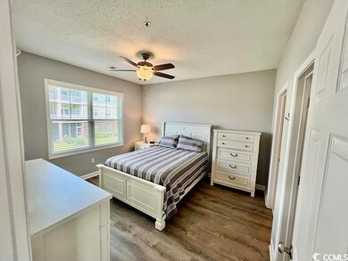 Bedroom with a textured ceiling, hardwood / wood-s