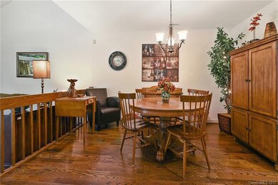 Spacious dining room with warm wood floors and ope