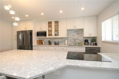 Kitchen featuring stainless steel microwave, white
