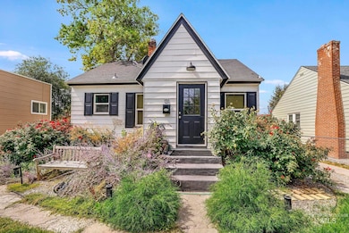 Bungalow-style home featuring a chimney and roof with shingles