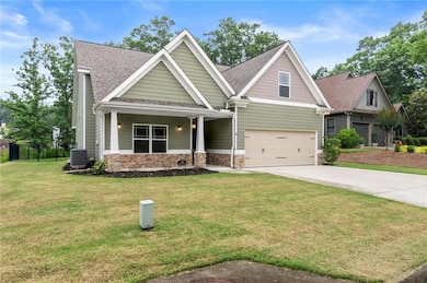 Craftsman inspired home featuring driveway, stone siding, roof with shingles, an attached garage, and covered porch