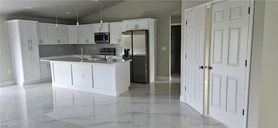 Kitchen featuring decorative light fixtures, sink,