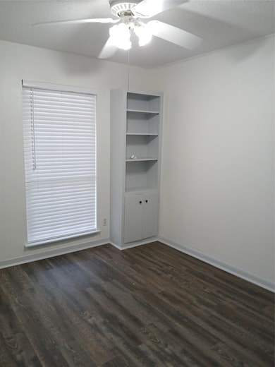 Spare room with dark wood finished floors, ceiling fan, and a textured ceiling