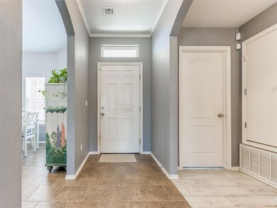 Foyer with arched walkways and crown molding