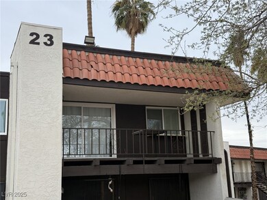 Back of house featuring a tile roof, a chimney, an