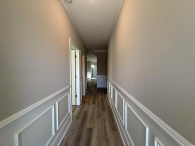 Hallway with dark wood-type flooring, a decorative