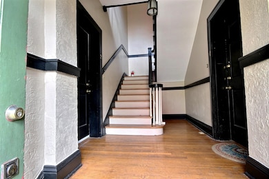 Staircase featuring a textured wall and wood finished floors