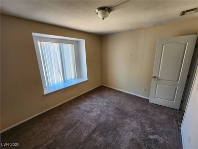 Empty room featuring visible vents, baseboards, a