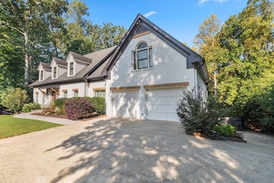 View of front of property featuring brick siding, driveway, and an attached garage