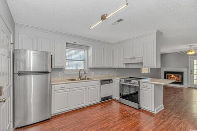 Kitchen with visible vents, under cabinet range hood, a peninsula, stainless steel appliances, and a sink
