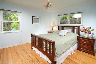 The master suite is drenched in natural light and is further highlighted by a two-tone designer paint scheme, crown molding, drop down chandelier on dimmer, ample closet space with built-in shelves and drawers to maximize storage and striking hardwoo