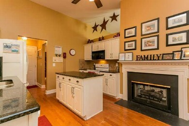 Large kitchen with granite countertops, hardwood floors and top of the line Samsung appliances. Also, notice the other side of the fireplace.