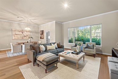 Living area with wood finished floors, a chandeli