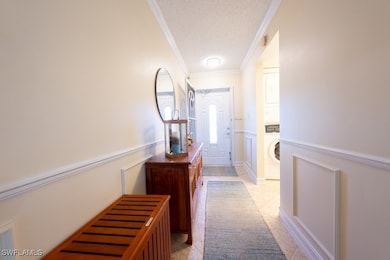 Hallway featuring a textured ceiling, stacked wash