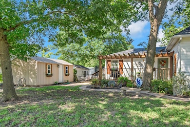 The outbuilting shown here has power and a window unit. The building behind it is a storage shed. A favorite spot in this property is the deck with pergola shown here.