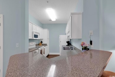 Kitchen with white appliances, sink, kitchen penin