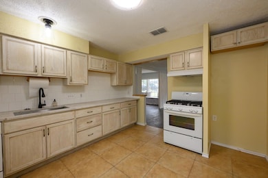 Kitchen featuring light brown cabinetry, white ra