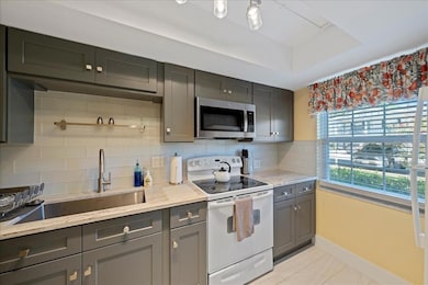 The updated kitchen boasts solid wood shaker-style cabinets, granite countertops, a large farmhouse sink, and a tasteful tile backsplash in clean, modern colors.