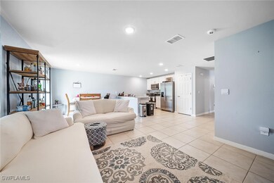 Living room with light tile patterned flooring, baseboards, visible vents, and recessed lighting