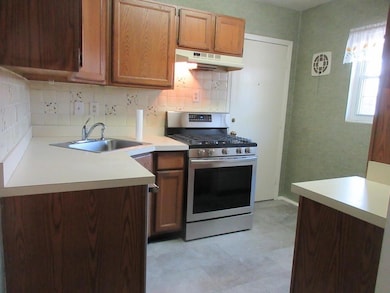 Kitchen featuring a sink, decorative backsplash, l
