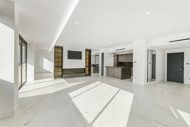 The open living area invites connection—where gatherings flow naturally from the spacious seating area to a kitchen that impresses with its Poggenpohl cabinetry and Gaggenau appliances. Every detail reflects a commitment to style, quality, and effortless modern living.