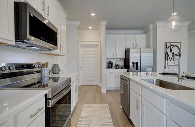 Kitchen featuring white cabinets, stainless steel 