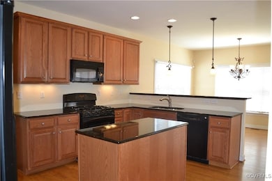 Kitchen featuring a sink, black appliances, a peni