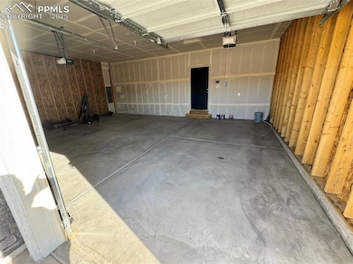 Garage featuring wood walls and a garage door open