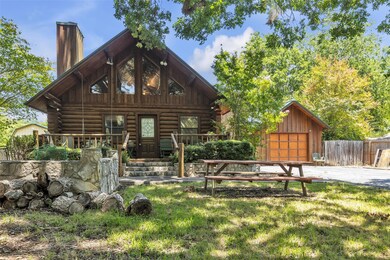 View of front of home featuring log siding, a chi