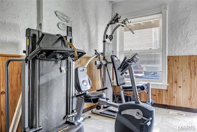 Workout area featuring wooden walls and baseboards