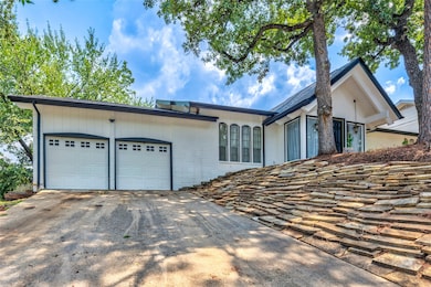 Ranch-style house featuring an attached garage, concrete driveway, and brick siding