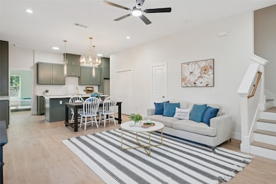 Living room featuring light wood-style flooring, recessed lighting, a chandelier, stairway, and ceiling fan