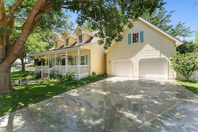View of front of house with covered porch, a garage, driveway, and a front yard