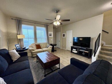 Living area with stairs, light tile patterned flo