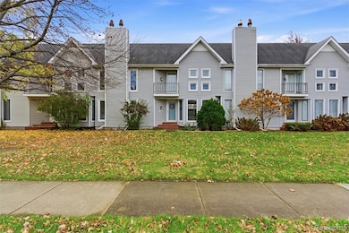 Traditional-style home featuring a chimney, a front yard, and a balcony