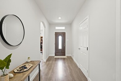 Entryway showcasing the stylish front door, recessed lighting, and access to other rooms through the hallway arches.