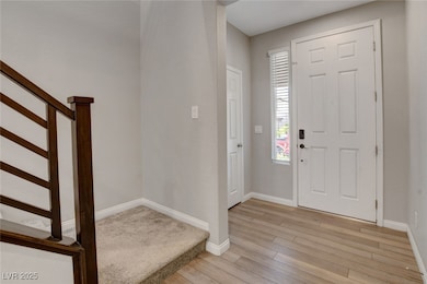 Foyer featuring light wood-style flooring, baseboa