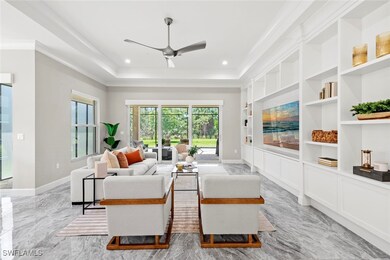 Living area featuring a tray ceiling, baseboards,