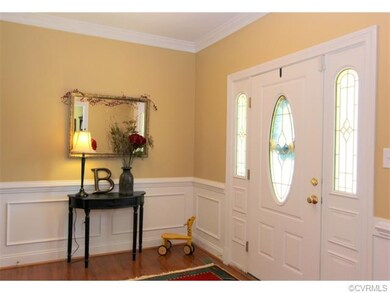 OPEN FOYER WITH PICTURE FRAME MOLDING AND HARDWOOD