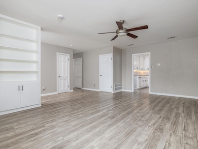 Unfurnished living room with a ceiling fan and li
